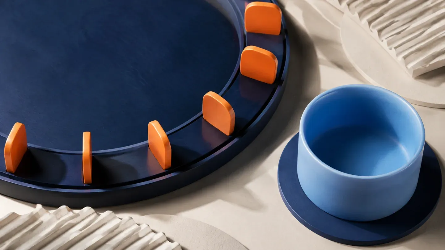 Orange tabs sit at regular intervals on a navy track beside a blue cup.