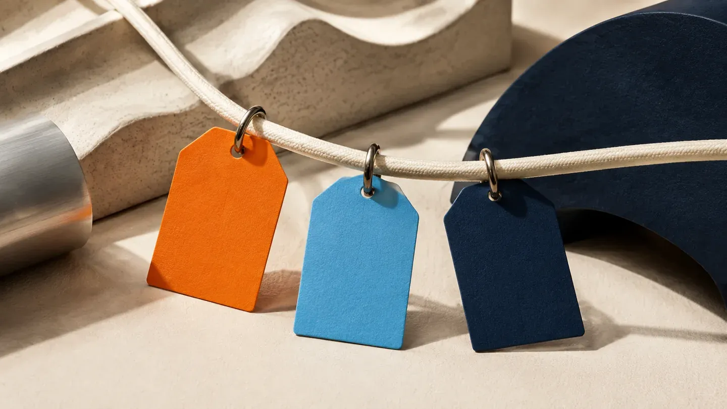 Three blank colored tags clip onto a cream cable with small metal rings.